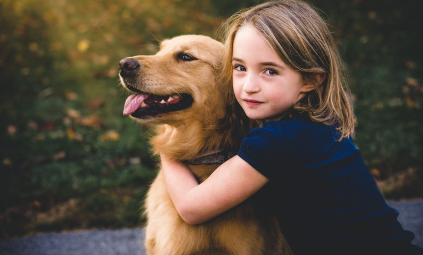 Picture of a child with a dog in order to answer how to convince your parents to get a dog.